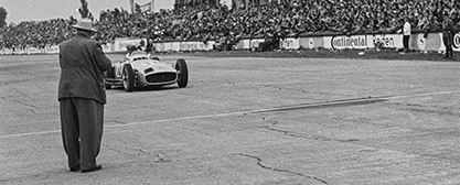 Großer Preis von Europa, 1. August 1954: Rennleiter Alfred Neubauer (Vordergrund) erwartet seinen siegreichen Werkspiloten Juan Manuel Fangio im Mercedes-Benz W 196 im Ziel. Foto: Daimler AG