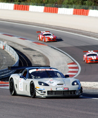 Bender (Dijon) in der Corvette vor den Stucky-Brüdern (CH) auf Ferrariroten SLS-Modellen